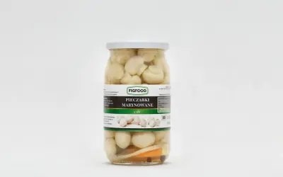 Słoik z marynowanymi pieczarkami marki Figfood, z widocznymi kawałkami warzyw na dnie.