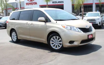 Złoty minivan Toyota Sienna stoi przed salonem Toyota Redlands.