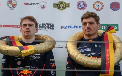 Max Verstappen celebra su victoria en el Nürburgring con un collar dorado y la bandera alemana.