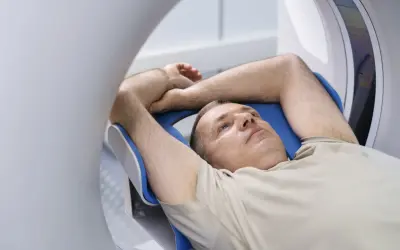 Mężczyzna leży w rezonansie magnetycznym. Zastanawia się, czy przed rezonansem można jeść.