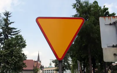 Żółty trójkątny znak drogowy informuje o ustąpieniu pierwszeństwa.