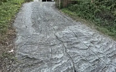 Stromy podjazd z popękanego betonu, z widocznymi śladami po koleinach. Zastanawiasz się, czym wyłożyć stromy podjazd?