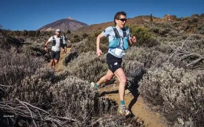Coureurs en plein effort sur un sentier rocailleux, le Teide en arrière-plan, lors du **Tenerife Bluetrail**.