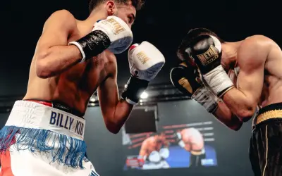 Two boxers face off, their gloves raised in a defensive stance. The hand placement shows readiness for a swift counter-attack.