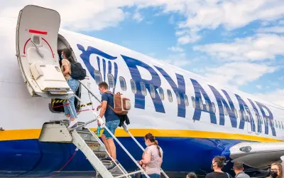 Pasażerowie wsiadają na pokład samolotu Ryanair. Czy Ryanair jest bezpieczny? Tysiące lotów dziennie świadczy o zaufaniu.
