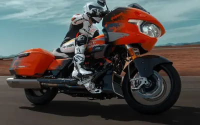 Pomarańczowy Harley-Davidson CVO z kierowcą w kombinezonie Alpinestars, pędzący po pustynnej drodze. To może być najdroższy motor na świecie.