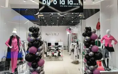 By o la la...! Kto jest właścicielem tego sklepu z modnymi ubraniami? Balony w kolorach czarnym, różowym i srebrnym ozdabiają wejście.
