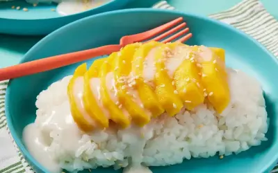 Pyszny deser mango sticky rice przepis. Kleisty ryż z kawałkami mango, polany mlekiem kokosowym i posypany sezamem.