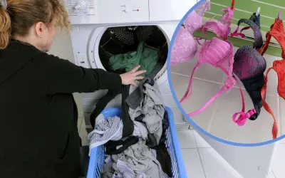 Frau lädt Wäsche in den Trockner. BHs trocknen an der Leine.