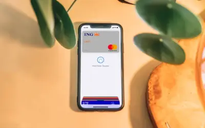 Telefon z kartą ING i napisem "Hold Near Reader" pokazuje, jak płacić Apple Pay. Szybko i bezpiecznie.