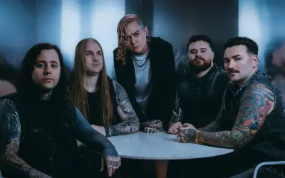 Zespół Lorna Shore Polska przy okrągłym stole, z tatuażami i w mrocznym klimacie.