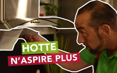 Un homme examine sa hotte neuve qui n'aspire pas. Il vérifie le filtre, cherchant la cause du problème.