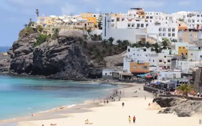 Piękna plaża i białe domy na Fuerteventurze. Idealne miejsce na wakacyjny **fuerteventura plan zwiedzania**.