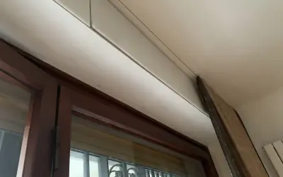 Dettaglio di un cassonetto tapparelle in fase di rimozione, con pannello in legno appoggiato.
