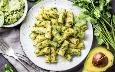 Pyszny makaron z pesto, podany z awokado i świeżymi ziołami. Idealny na szybki obiad.