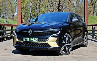 Nowy Renault Austral, czarna marka samochodu na drewnianym moście, z elementami w kolorze złota.