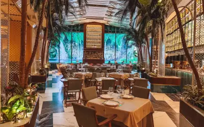 Tropische Atmosphäre in einem der Restaurants in Valencia. Palmen und ein Wasserfall-Bild im Hintergrund schaffen ein einzigartiges Ambiente.