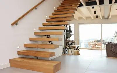 Ein modernes Treppenhaus gestalten: Schwebende Holzstufen mit integrierten Leuchten und einem schlichten Holzhandlauf.