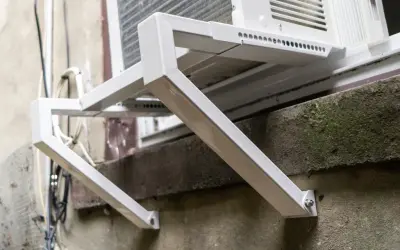 Solidne oparcie dla ramy okiennej, wykonane z białego metalu, zapewnia stabilne mocowanie klimatyzatora.