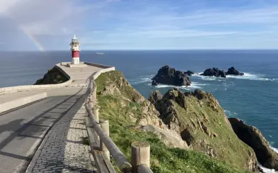 Faro en Cabo Ortegal con arcoíris. Un paisaje espectacular que ver, con el mar azul y rocas escarpadas.