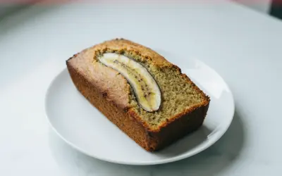 Chlebek bananowy z airfryera, idealnie wypieczony, z plasterkiem banana na wierzchu.