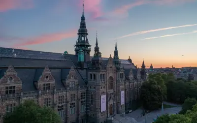 Nordiska museet badar i solnedgångens rosa sken.