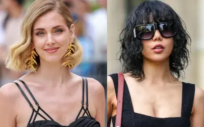 Dwie kobiety w czarnych kreacjach. Jedna z blond włosami w stylu italian bob, druga z ciemnymi, kręconymi włosami i okularami.