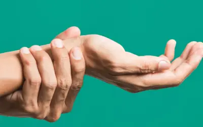 Mano che si tiene il polso, indicando dolore o fastidio, forse legato all'artrite polso.