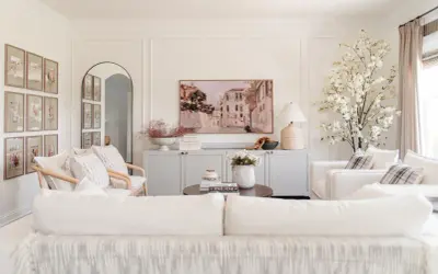 Elegant living room with a Venetian canal painting above a gray credenza. The walls feature decorative molding, adding a classic touch.