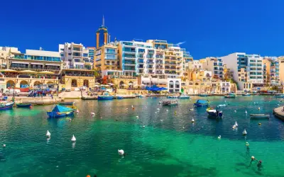 Malta, St Julian's: malowniczy port z turkusową wodą, łodziami i nowoczesnymi budynkami.
