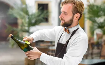 Barman przygotowuje szampana, dbając o to, by nie psuł się, zanim trafi do klienta.