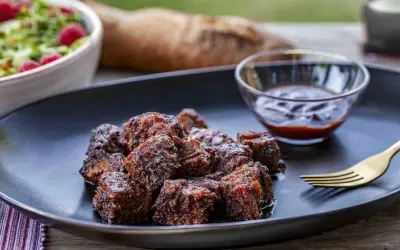 Saftige, karamellisierte **burnt ends** auf einem Teller mit BBQ-Sauce und Salat. Ein Fest für Fleischliebhaber!