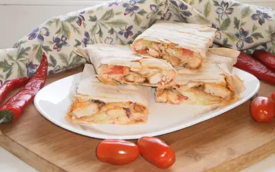 Pyszny lawasz z warzywami i kurczakiem, podany z papryczkami chili i pomidorkami.