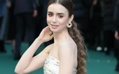 Lily Collins, gwiazda serialu "Emily w Paryżu", w kwiecistej sukni i z błyszczącymi kolczykami.
