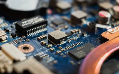 Zbliżenie na niebieską płytę główną z widocznymi elementami elektronicznymi, w tym układem **cmos**.