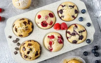Saftige Muffins mit Schokolade, Himbeeren und Blaubeeren im Muffinblech. Ein köstliches Muffins Rezept für jeden Anlass.