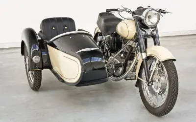 Moto con sidecar clásica, color crema y negro, lista para un paseo nostálgico.