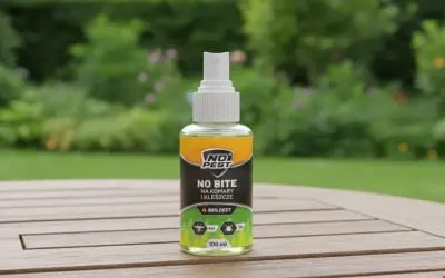 Butelka sprayu "No Bite" z 30% DEET, najmocniejszy środek na komary i kleszcze, na drewnianym stole w ogrodzie.