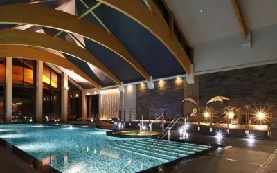 Luksusowe hotele na Mazurach z basenem oferują relaks w nowoczesnym stylu. Wnętrze basenu z podświetlanymi schodkami i jacuzzi.