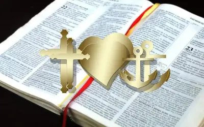 Złoty krzyż, serce i kotwica na otwartej Biblii. Te symbole wiary, nadziei i miłości, jak katarzy, wskazują drogę.