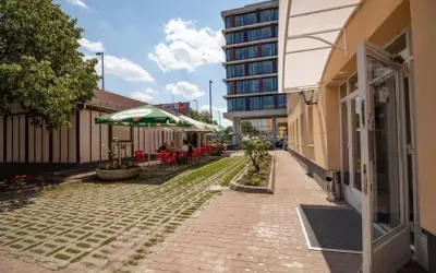 Letni dzień w kawiarni przy budapest nepliget. Stoliki pod parasolami, ludzie odpoczywają.