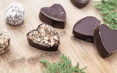Chocolats maison en forme de cœur, certains garnis de noix, parfaits pour une recette petit chocolat maison facile.