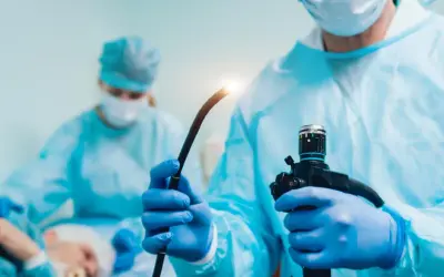 Lekarz w niebieskiej masce i fartuchu przygotowuje endoskop do badania, które może pomóc w diagnostyce przełyku Barretta.