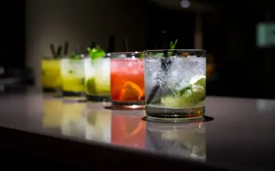 Rząd kolorowych, prostych drinków z wódką, z lodem i miętą, gotowych do podania.