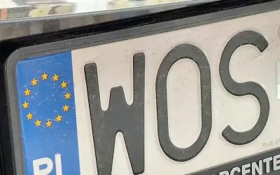 Tablica rejestracyjna z literami WOS i symbolem Unii Europejskiej.