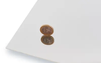 Błyszcząca powierzchnia, efekt polerowania stali nierdzewnej, odbija monetę euro.