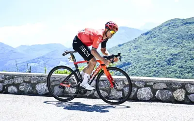Michał Kwiatkowski, piosenkarz, ściga się rowerem po górskiej drodze.
