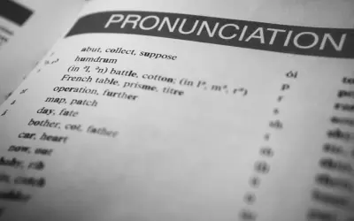 Otwarta książka z hasłem "PRONUNCIATION". Lista słów i symboli fonetycznych pokazuje, czy angielski jest trudny.
