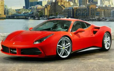 Czerwone Ferrari 488 GTB z dumą prezentuje się na tle Londynu, z Tower Bridge w tle.