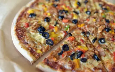 Pyszna pizza z oliwkami i kolorową papryką, jeden z wielu apetycznych rodzajów pizzy.